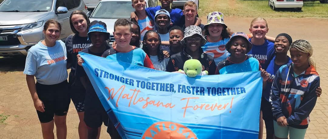 swim instructor teaching swimming with kickboards